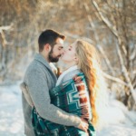 man and woman hugging each other about to kiss during snow season